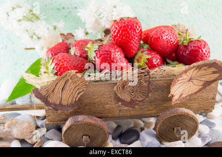 Mazzetto di fragole fresche impilati sul vecchio in miniatura carri Foto Stock