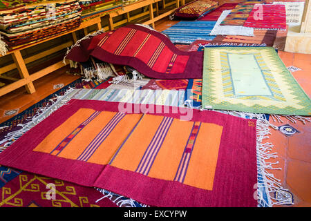 Tradizionali tessuti a mano tappeti sul visualizzatore in corrispondenza di un tessitore shop in Teotitlan del Valle in Messico Oaxaca Foto Stock