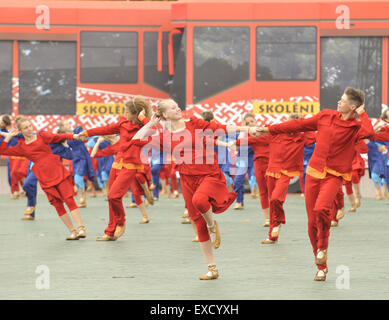 Riga, Lettonia. 11 Luglio, 2015. Scolari danza nella formazione come essi partecipano in un folk-spettacolo di danza come parte della scuola di canto e danza Festival in Riga, capitale della Lettonia, il 11 luglio 2015. In costumi tradizionali tipici di ogni regione della Lettonia, scolari provenienti da tutto il paese Baltico riuniti nella capitale Riga di questa settimana per la scuola di canto e danza Festival. © Guo Qun/Xinhua/Alamy Live News Foto Stock