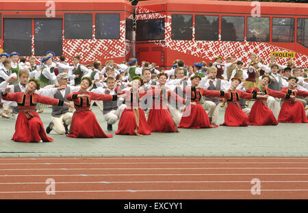 Riga, Lettonia. 11 Luglio, 2015. Scolari danza nella formazione come essi partecipano in un folk-spettacolo di danza come parte della scuola di canto e danza Festival in Riga, capitale della Lettonia, il 11 luglio 2015. In costumi tradizionali tipici di ogni regione della Lettonia, scolari provenienti da tutto il paese Baltico riuniti nella capitale Riga di questa settimana per la scuola di canto e danza Festival. © Guo Qun/Xinhua/Alamy Live News Foto Stock