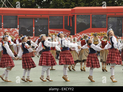 Riga, Lettonia. 11 Luglio, 2015. Scolari danza nella formazione come essi partecipano in un folk-spettacolo di danza come parte della scuola di canto e danza Festival in Riga, capitale della Lettonia, il 11 luglio 2015. In costumi tradizionali tipici di ogni regione della Lettonia, scolari provenienti da tutto il paese Baltico riuniti nella capitale Riga di questa settimana per la scuola di canto e danza Festival. © Guo Qun/Xinhua/Alamy Live News Foto Stock