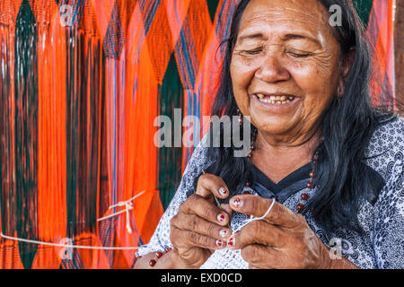 Anziani Wayuu donna indigena la tessitura di una 'chinchorro' o amaca colombiana. Lavorazione a maglia, a crochet e tessitura sono fondamentali per Foto Stock