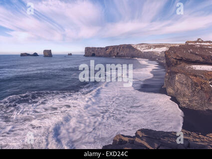 Le scogliere e spiaggia di sabbia nera sulla costa sud dell'Islanda vicino a VIK. Foto Stock