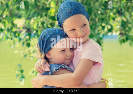 Carino divertente bambine (suore) sorriso, il fuoco selettivo. Foto Stock