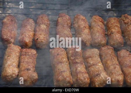 Cottura alla brace la carne macinata, tradizionale Rumena preparazione per barbecue, denominato "Ici", sul fuoco di carbone - primo piano immagine. Foto Stock
