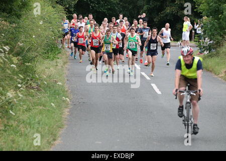 Timberhonger 10k corridori in competizione in 10k gara lungo Timberhonger Lane a Bromsgrove in Inghilterra il 11 Luglio 2015 Foto Stock
