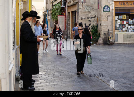 Due ebrei ortodossi uomini leggendo la Torah, chiedendo donazioni nel quartiere ebraico a Le Marais, Paris, Francia. Foto Stock