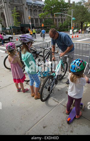 Giovane ciclista bloccando la sua bicicletta con aiuto da parte di un adulto sul ciglio della strada New York STATI UNITI D'AMERICA Foto Stock