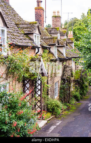 English Cotswold village di Winchcomb, vista della piccola riga della terrazza del XIX secolo case di pietra lungo la corsia, uno con i pergolati in legno attorno alla parte anteriore della porta. Foto Stock