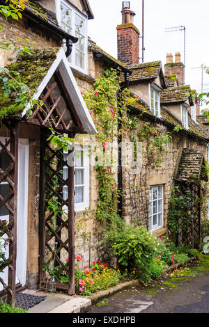 English Cotswold village di Winchcomb, vista della piccola riga della terrazza del XIX secolo case di pietra lungo la corsia, uno con i pergolati in legno attorno alla parte anteriore della porta. Foto Stock