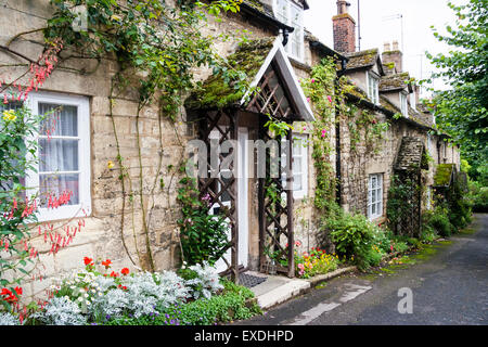 English Cotswold village di Winchcomb, vista della piccola riga della terrazza del XIX secolo case di pietra lungo la corsia, uno con i pergolati in legno attorno alla parte anteriore della porta. Foto Stock