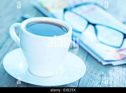 Il caffè nella tazza e su un tavolo Foto Stock