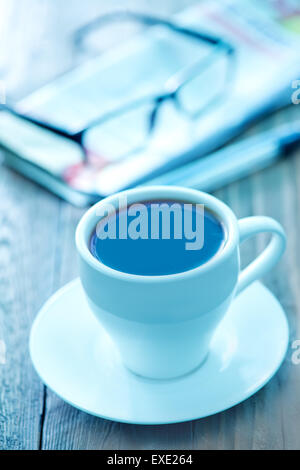 Il caffè nella tazza e su un tavolo Foto Stock