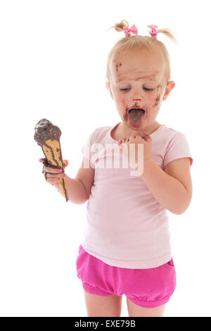 Ritratto toddler ragazza di mangiare il gelato al cioccolato isolate su sfondo bianco Foto Stock