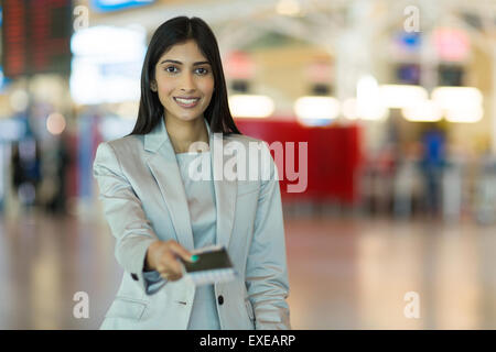 Felice donna indiana Consegna biglietto aereo compagnia aerea al banco del check in Foto Stock