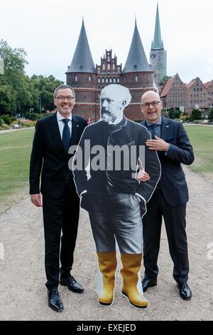 Lubecca, Germania. 12 Luglio, 2015. Kuhnt cristiana (l), un operatore del Schleswig-Holstein Music Festival (SHMF) e Torsten Albig (SPD), il primo ministro del Land Schleswig-Holstein posano con una dimensione di vita figurina del compositore russo Pyotr Ilyich Tchaikovsky prima la porta Holsten a Lubecca, Germania, 12 luglio 2015. Tchaikovsky la musica è un punto culminante di quest'anno del festival di musica che è cominciato domenica ed è in esecuzione fino al 20 Ausgust 2015. Foto: Markus Scholz/dpa/Alamy Live News Foto Stock