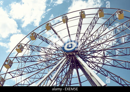 Ruota panoramica Ferris contro il cielo blu con nuvole, effetto tonificante Foto Stock