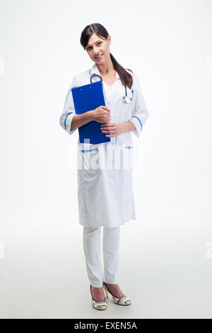 A piena lunghezza Ritratto di un felice medico con appunti in piedi isolato su uno sfondo bianco Foto Stock