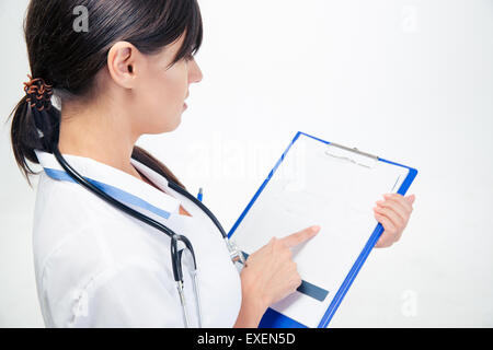 Ritratto di un giovane medico leggere le note sul clipboard isolato su uno sfondo bianco Foto Stock