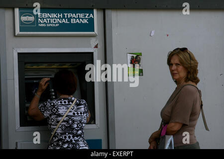 Atene, Grecia. 13 Luglio, 2015. Linea di persone fino al di fuori di una banca per ritirare euro ad Atene, Grecia, 13 luglio 2015. Il vertice della zona euro ha finalmente raggiunto un accordo di salvataggio con la Grecia il lunedì mattina dopo 17 ore di difficili discussioni, Eurozona leader ha annunciato. Credito: Marios Lolos/Xinhua/Alamy Live News Foto Stock