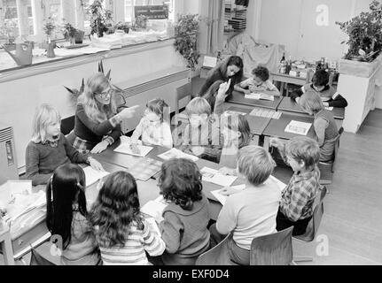 Questa fotografia d'epoca cattura una classe piena di studenti in un ambiente storico. L'immagine riflette l'ambiente educativo del tempo, con gli studenti seduti alle scrivanie, probabilmente all'inizio del XX secolo, che mostrano la tradizionale disposizione dell'aula. Foto Stock