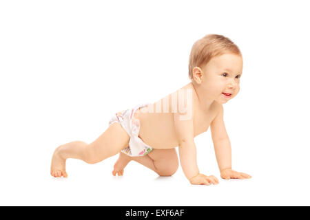 Studio shot di un adorabile piccola bambina di strisciare sul pavimento e sorridente isolati su sfondo bianco Foto Stock