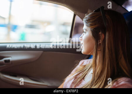 Giovane donna guardando fuori della finestra dei taxi a Manila, Filippine Foto Stock