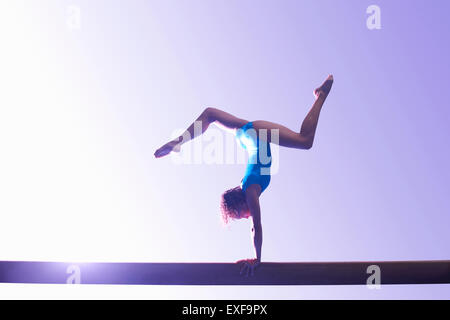 Giovane ginnasta eseguendo sulla trave di equilibrio Foto Stock