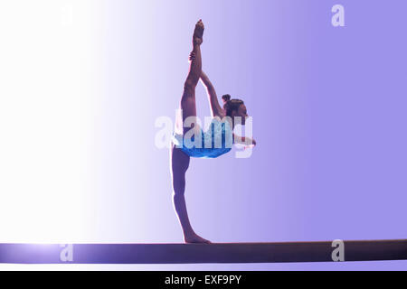 Giovane ginnasta eseguendo sulla trave di equilibrio Foto Stock