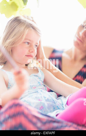 Figlia seduti sulla madre di giro Foto Stock