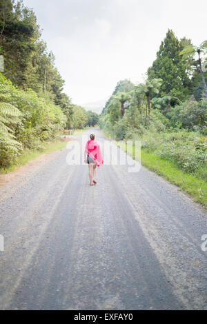 La donna a piedi sulla strada diritta Foto Stock