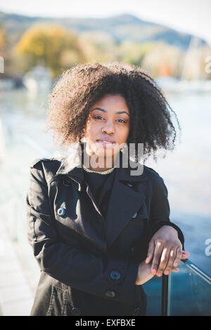 Ritratto di giovane donna appoggiata contro park ringhiere Foto Stock