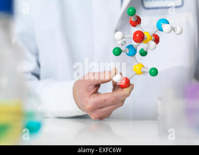 Scienziato tenendo un modello molecolare di una formula chimica Foto Stock