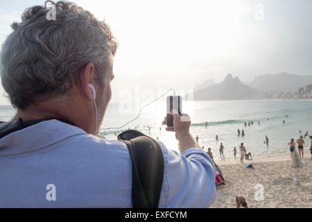 L'uomo prendendo foto di vista, la spiaggia di Ipanema, Rio de Janeiro, Brasile Foto Stock