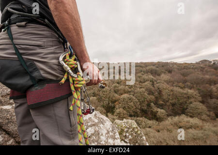 Maschio di rocciatore con moschettone e corda di arrampicata Foto Stock