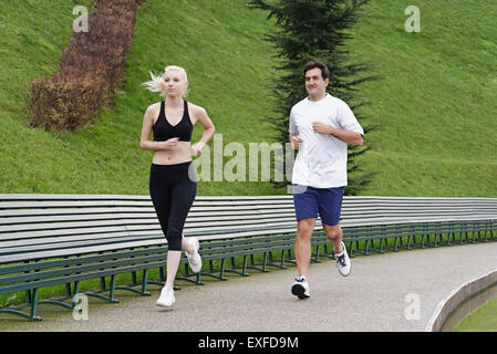 L uomo e la donna in esecuzione sul sentiero accanto al lago Foto Stock