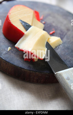 Formaggio Gouda su un tagliere con fette, coltello e spazio di copia Foto Stock