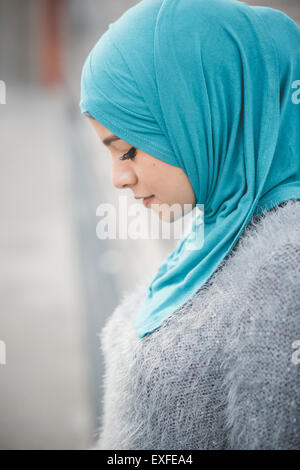 Close up ritratto di giovane donna che indossa il turchese hijab su passerella Foto Stock