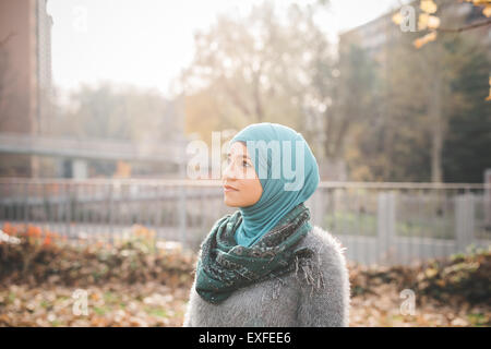 Ritratto di giovane donna che indossa il hijab fissando in posizione di parcheggio Foto Stock