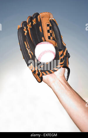 Stretta di mano femmina tenendo palla indossando guanti da baseball, Miami, Florida, Stati Uniti d'America Foto Stock