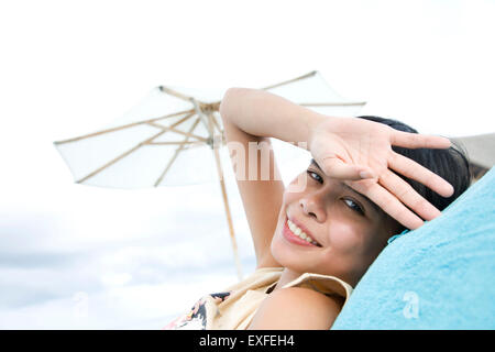 Ritratto di donna rilassante sulla spiaggia, atollo di Ari, Maldive Foto Stock