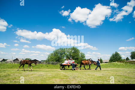 Famiglia a cavallo e il carrello in campo, Rezh, Sverdlovsk oblast, Russia Foto Stock