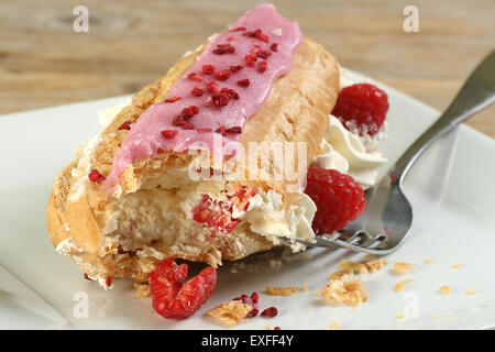 Crema unica riempito con eclair rapberries fresco e lampone ciliegina Foto Stock