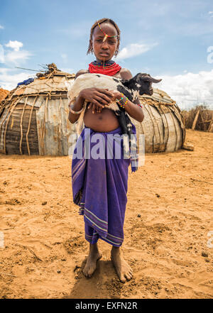La ragazza da tribù africana Dasanesh tenendo una capra nel suo villaggio Foto Stock