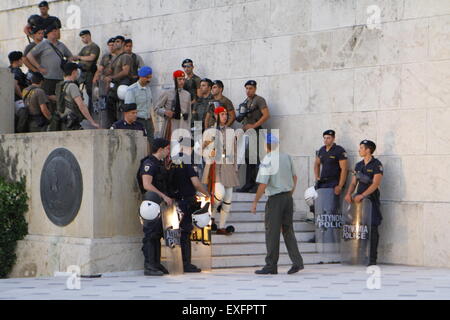 Atene, Grecia. 13 Luglio, 2015. Il Evzones (Greco guardie presidenziali) tornare alla Piazza Syntagma attraverso una fila di sommossa a funzionari di polizia. Essi avevano ritirato in precedenza durante la protesta. I Greci assemblati al di fuori del parlamento greco sotto la bandiera del "dobbiamo lasciare questo l'Europa". Essi hanno chiesto al governo di non dare alle richieste dei creditori greca per ulteriori misure di austerità, ma piuttosto di lasciare la zona euro. © Michael Debets/Pacific Press/Alamy Live News Foto Stock