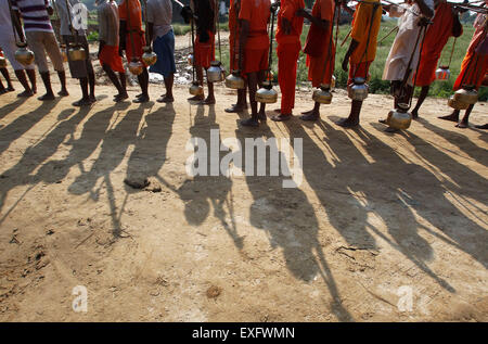 Di Allahabad, India. 13 Luglio, 2015. Kanwarias indù, adoratori di Dio indù Shiva, trasportare contenitori metallici riempiti con acqua santa di Gange fiume come si cammina verso Padilla Mahadev tempio sulla periferia di Allahabad. © Ravi Prakash/Pacific Press/Alamy Live News Foto Stock