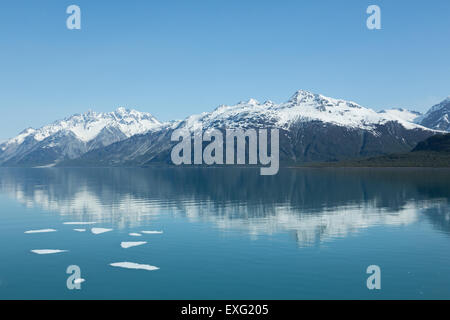 Iceberg galleggiante di fronte montagne riflettente in Alaska di Glacier Bay Foto Stock