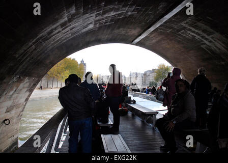 Imbarcazione turistica di andare sotto un ponte sul Fiume Senna, Parigi Foto Stock