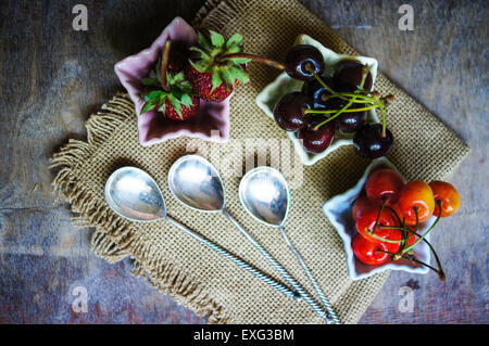 Tre a forma di stella ciotole con frutta fresca di stagione - fragola e due tipi di ciliegie Foto Stock