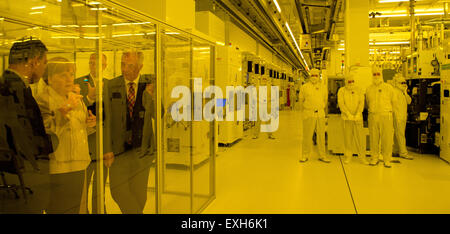 Dresden, Germania. 14 Luglio, 2015. CEO di Globalfoundries, Sanjay K. GAI (L-R), il Cancelliere tedesco Angela Merkel, Managing Director di Globalfoundries Fab1, Rutger Wijburg, e della Sassonia Ministropresidente Stanislaw Tillich esaminare la camera sterile attraverso un pannello di vetro sul sito della società Globalfoundries Fab1 di Dresda, in Germania, il 14 luglio 2015. Merkel stessa informato sui nuovi sviluppi sul sito per la microelettronica. Foto: ARNO BURGI/dpa/Alamy Live News Foto Stock